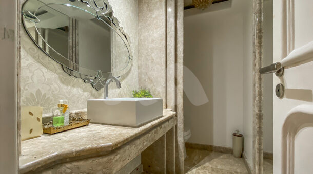 Imagem de lavabo com bancada e cuba e espelho planejado em casa a venda no condominio de alto padroa na barra da tijuca