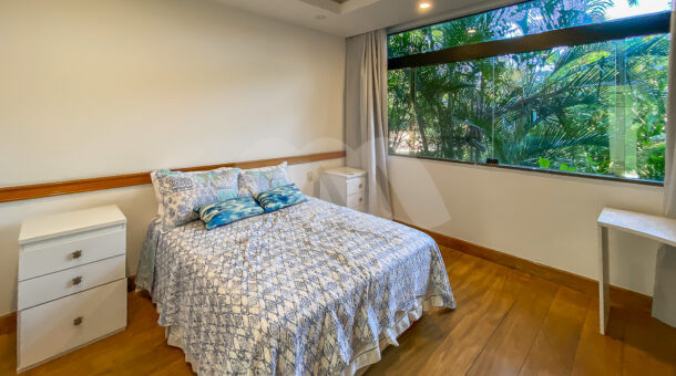 Imagem de quarto com cama de casal e ampla janela com vista para jardim da casa triplex a venda