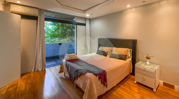 Imagem de quarto com cama de casal e porta de vidro com acesso a varanda da casa triplex a venda