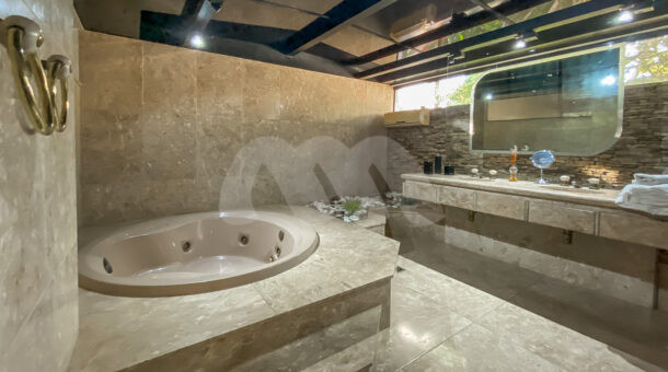 Imagem de banheiro de suite com banheira de hidromassagem e ampla bancada em casa a venda na barra