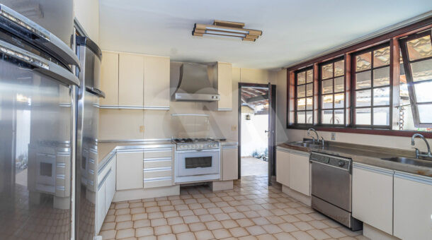 Imagem da cozinha com ampla bancada da casa triplex com 2200m² de terreno à venda no Park Palace