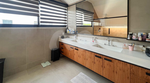 Imagem lateral do banheiro com vista da pia da mansão contemporânea à venda.