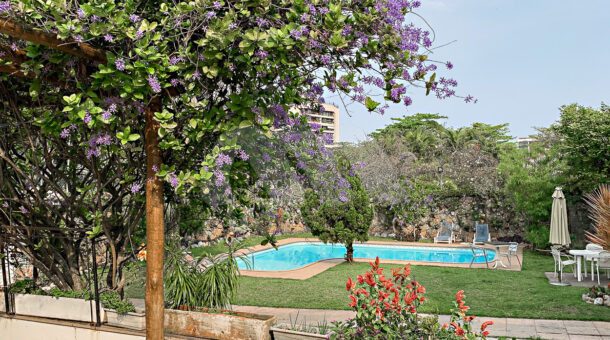 Imagem de amplo quintal com grama e piscina em casa duplex a venda