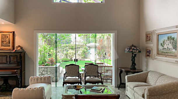 Imagem de sala de estar com pe direito duplo em casa a venda na Barra da Tijuca