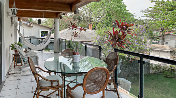 Imagem de varanda com mesa de almoço e rede em casa duplex a venda na santa marina