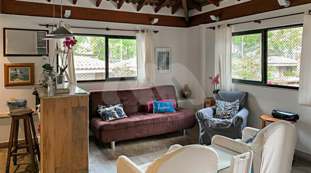 Imagem de sala de estar com sofá e poltronas em casa a venda na Barra