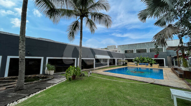 Imagem lateral da piscina com vista da área de lazer da casa à venda no Maramar.