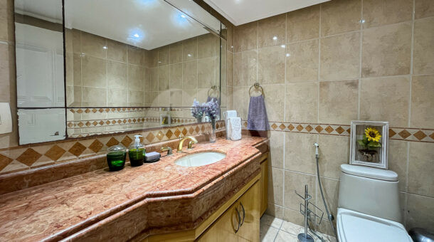 Imagem do banheiro com vista da pia vermelha da mansão moderna à venda na Muller Imóveis RJ.