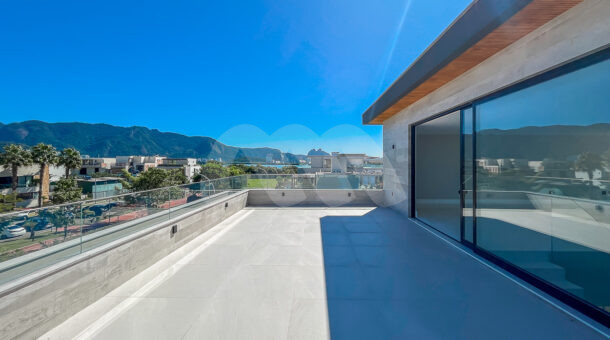 Imagem de varanda com vista para condominio e montanhas em casa contemporanea a venda na Barra da Tijuca