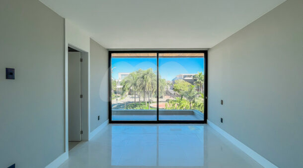 Imagem de amplo quarto com piso espelhado, porta de correr para varanda privativa em casa a venda na Barra
