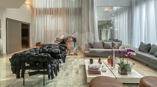 Imagem da sala com sofá da casa duplex de alto padrão à venda na Barra da Tijuca