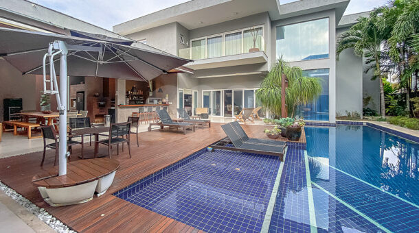 Imagem da área externa com piscina e deck molhado da casa duplex de alto padrão à venda na Barra da Tijuca