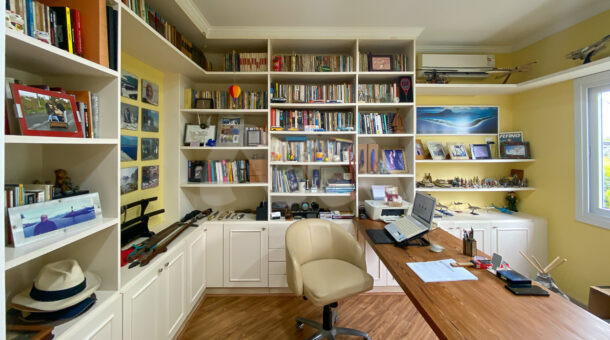 Imagem de escritorio com estante planejada e longa escrivaninha da casa triplex