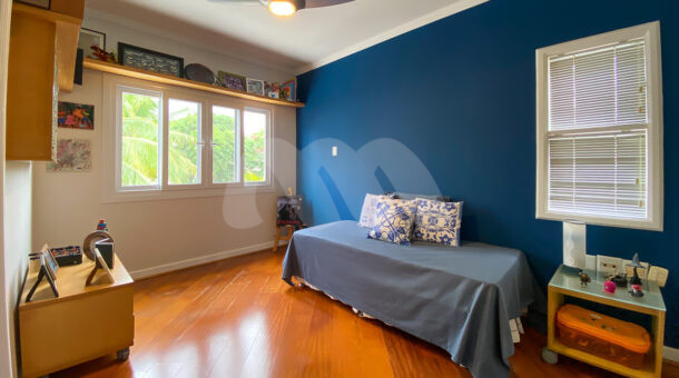 Imagem de quarto com moveis planejados e parede azul em casa a venda na barra da tijuca