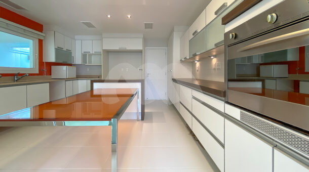 Imagem frontal da cozinha com vista da bancada do imóvel à venda na imobiliaria Muller Imóveis RJ.