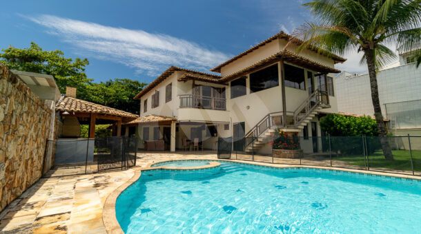 Imagem da ampla piscina com cascata e paisagismo da belissima casa no Recreio na imobiliária de luxo RJ