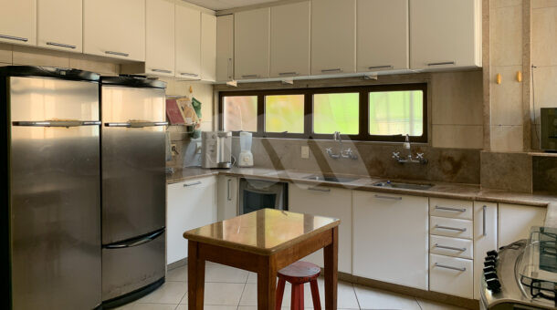 Imagem lateral da cozinha com vista dos móveis da casa à venda.