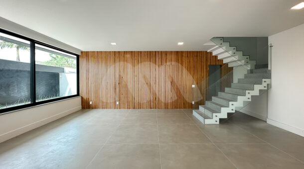 Imagem do hall de entrada com painel de madeira da casa à venda em luxuoso condomínio.