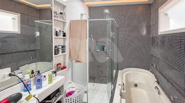 Imagem de banheiro de suite master com banheira de hidromassagem, bancada planejada e espelho vom nicho em casa a venda na Muller Imoveis