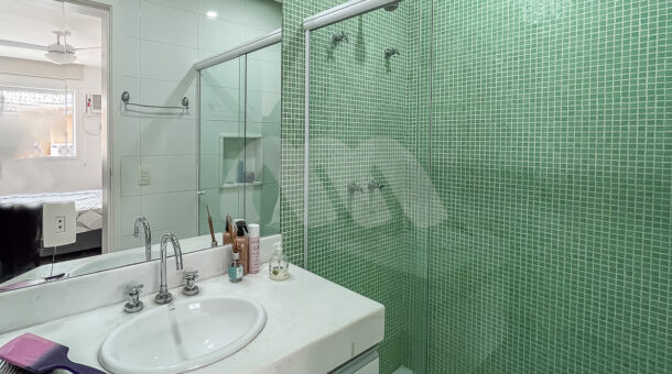 Imagem de banheiro de suite com bancada branca e armario planejado e bx em pastilha verde de casa linda a venda