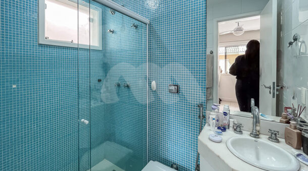 Imagem de banheiro de suite com pastilha azul e armario planejado com pia de casa classica