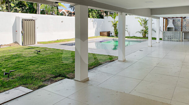 Imagem lateral da varanda com vista da piscina da casa à venda na Barra da tijuca.