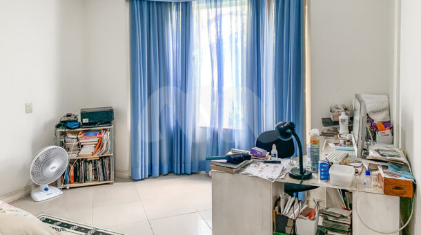Imagem lateral do quarto com escrivaninha do imóvel de luxo à venda.