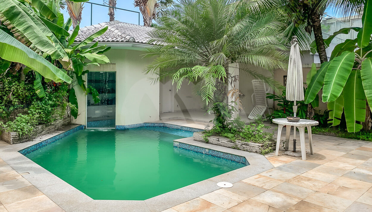 Imagem lateral da piscina com sauna da casa à venda em luxoso condomínio de mansões.