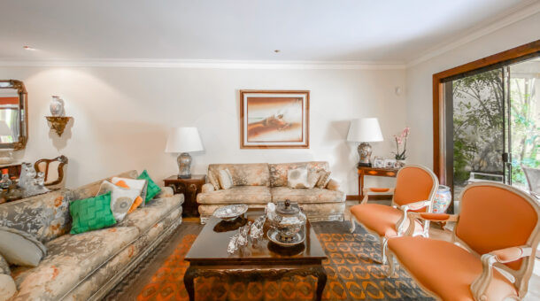 Imagem de sala de estar com sofás e poltronas em casa a venda na Barra da Tijuca