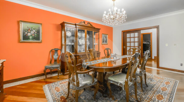 Imagem de sala de jantar com mesa de jantar em madeira e lustre em casa duplex a venda na barra da tijuca