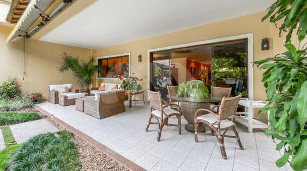 Imagem de varanda com mesa redonda em vidro e espaço lounge da casa duplex a venda na Barra