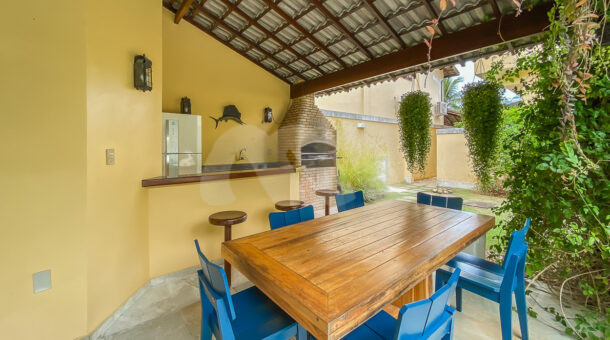 Imagem de area gourmet com bancada mesa de madeira e cadeiras azul em casa duplex a venda