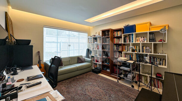 Imagem de escritorio com estantes de livros em casa triplex a venda na Barra