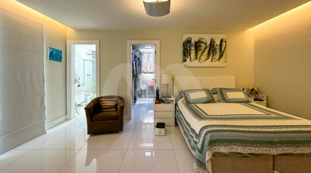 Imagem de quarto com cama de casal, closet e banheiro em casa triplex a venda na Barra