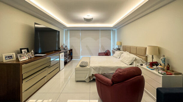 Imagem de quarto com cama de casal, rack e comoda e poltronas da casa a venda na Barra da Tijuca