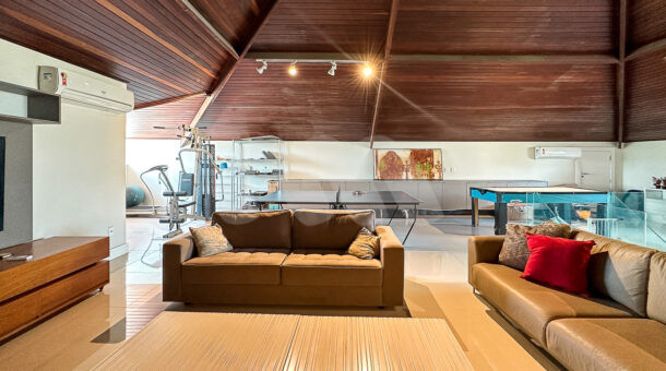 Imagem de amplo sotao com teto abobadado de madeira em casa triplex a venda na Barra