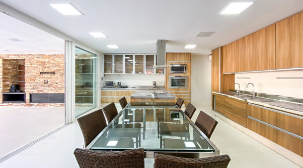 Imagem de cozinha com armarios planejados e mesa de almoço em vidro da casa triplex a venda