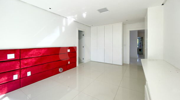 Imagem de amplo quarto com armários branco planejados em casa triplex a venda na Muller Imoveis RJ
