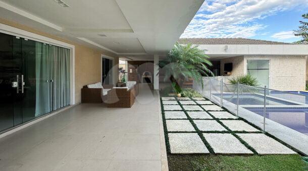 Imagem de varanda com piscina, gramas e pedras da casa triplex a venda