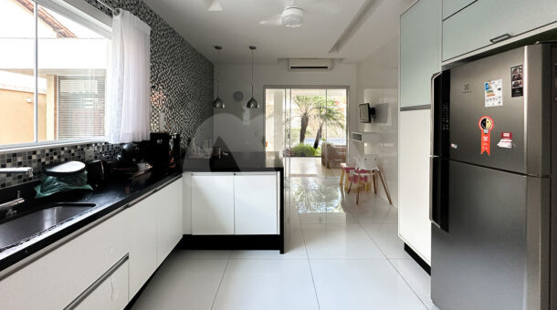 Imagem de ampla cozinha com armarios e bancada em peninsula da casa triplex a venda no condominio crystal lake