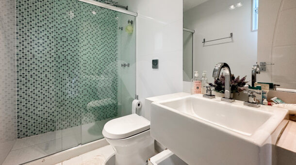Imagem de banheiro com bancada e cuba, e box de vidro da casa a venda na barra da tijuca