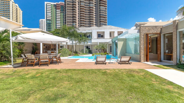 Imagem da área externa com piscina e com gramado da casa duplex com Jardim de Inverno á venda na Barra da Tijuca