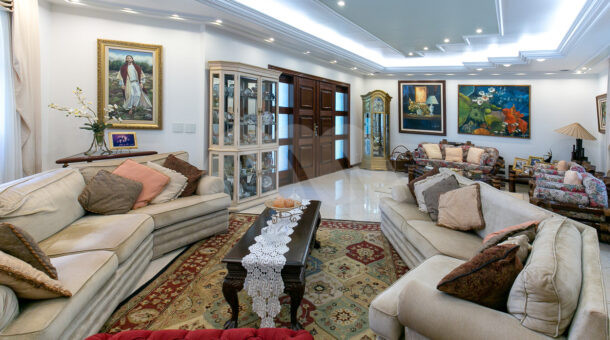 Imagem lateral da sala com vista das mobilias da casa à venda.