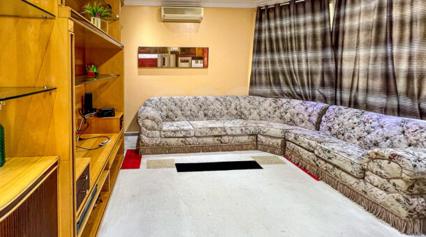 Imagem de sala de tv com sofá em formato de L e estante com painel de tv da Casa duplex