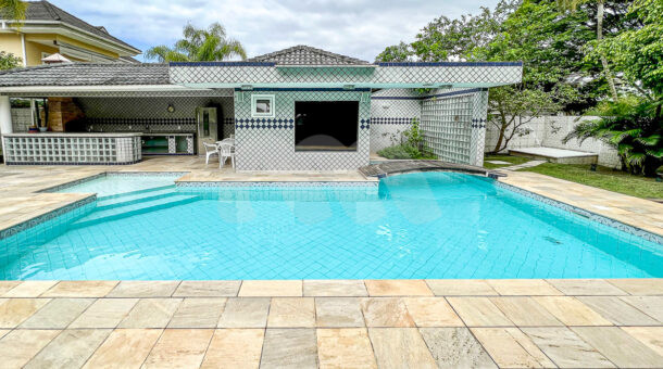 Imagem de ampla piscina com acesso a sauna e area gourmet em casa duplex a venda na Barra