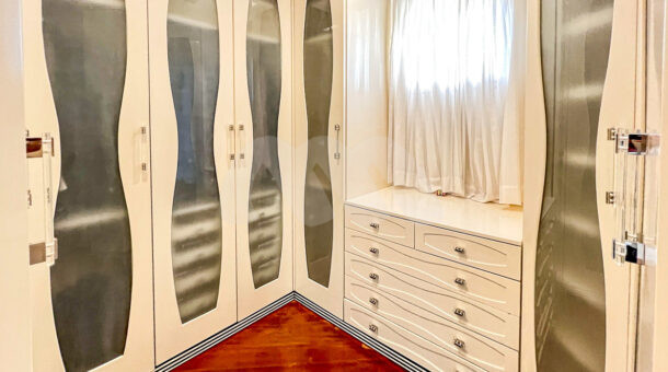 Imagem de closet com armarios planejados e piso em madeira ype em casa duplex