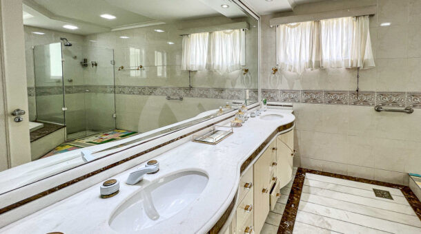 Imagem de banheiro de suite master com bancada com cuba dupla e amplo espelho