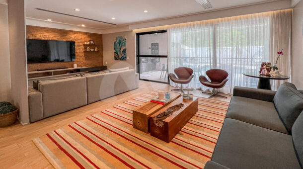Imagem da sala com tv dividida em dois ambientes da Linda casa triplex à venda no Interlagos de Itaúna, na Barra da Tijuca RJ