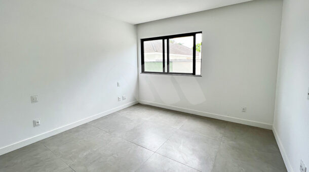 Imagem de quarto com porcelanato cinza e paredes brancas em casa de alto padrão à venda