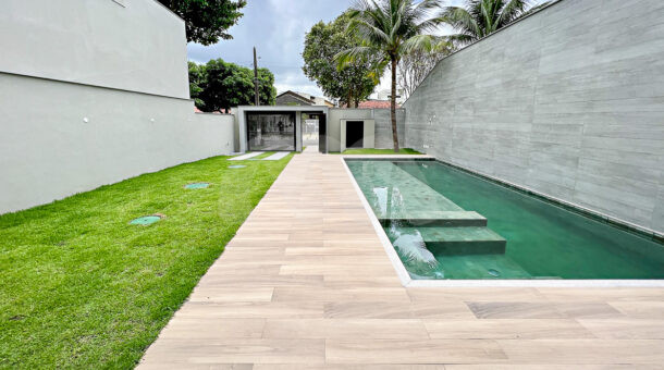 Imagem de area externa de casa contemporanea com gramado, deck e piscina